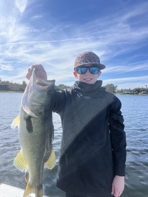 Young angler holding a largemouth bass on a clear winter afternoon, Winter Haven Chain of Lakes